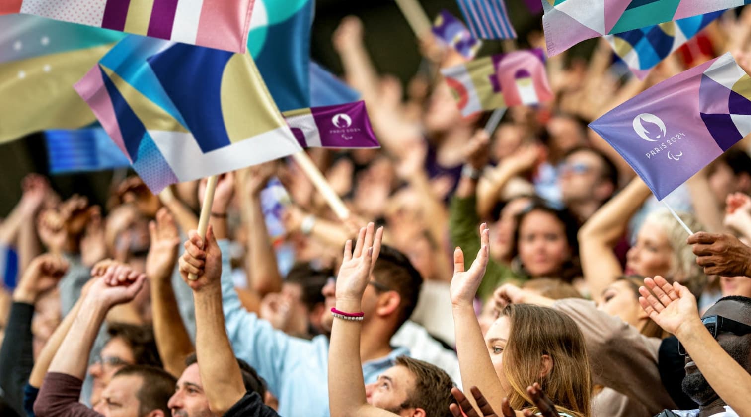 Foule de personne agitant des drapeaux aux couleurs des JO 2024